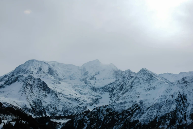 the mountains are covered in snow with very few clouds