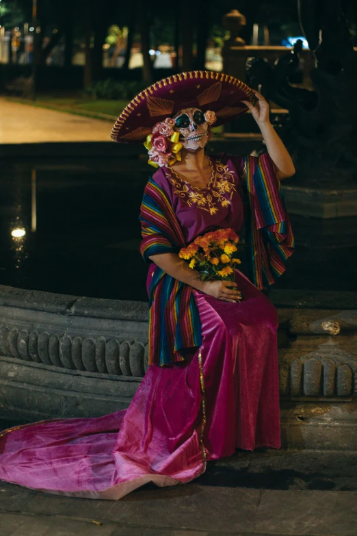 a mexican woman sits on the curb with her hand in her mouth