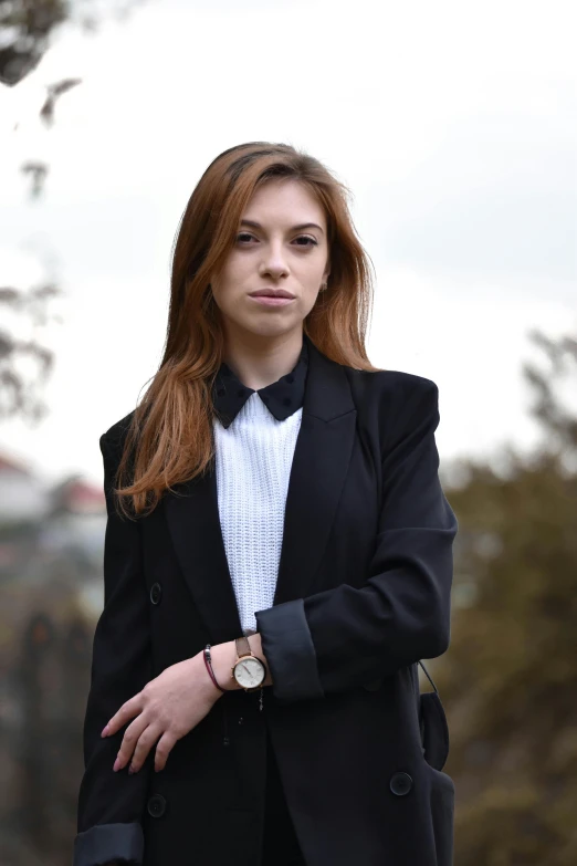 a girl in a black suit with a watch