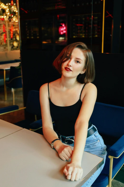 a woman sits at a table in front of a mirror