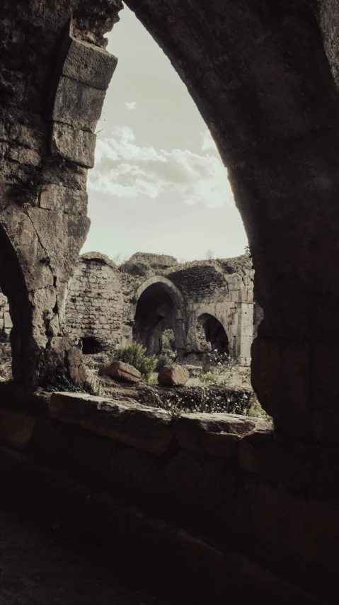 an archway in a stone structure is seen through the sky