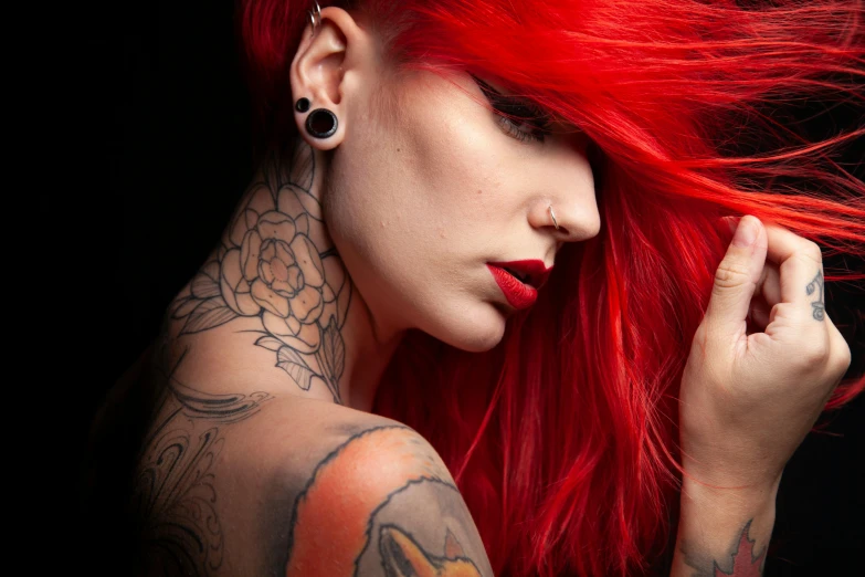 a tattooed woman with red hair and piercings