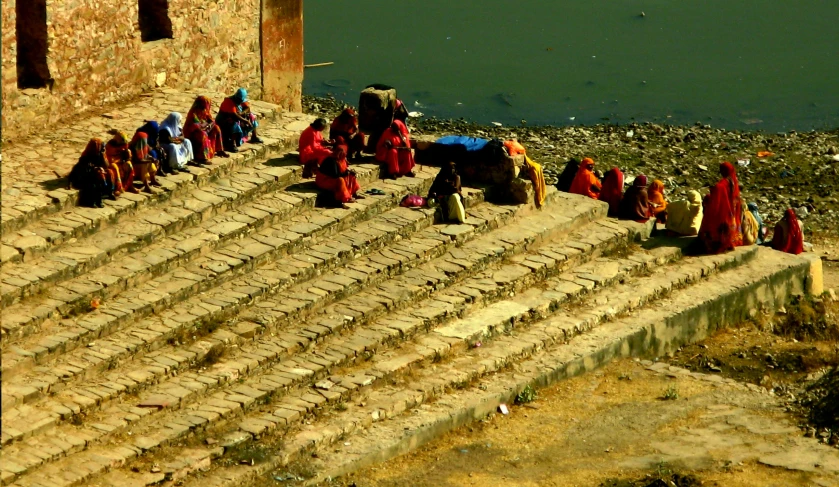 women sitting and standing at the top of a mountain