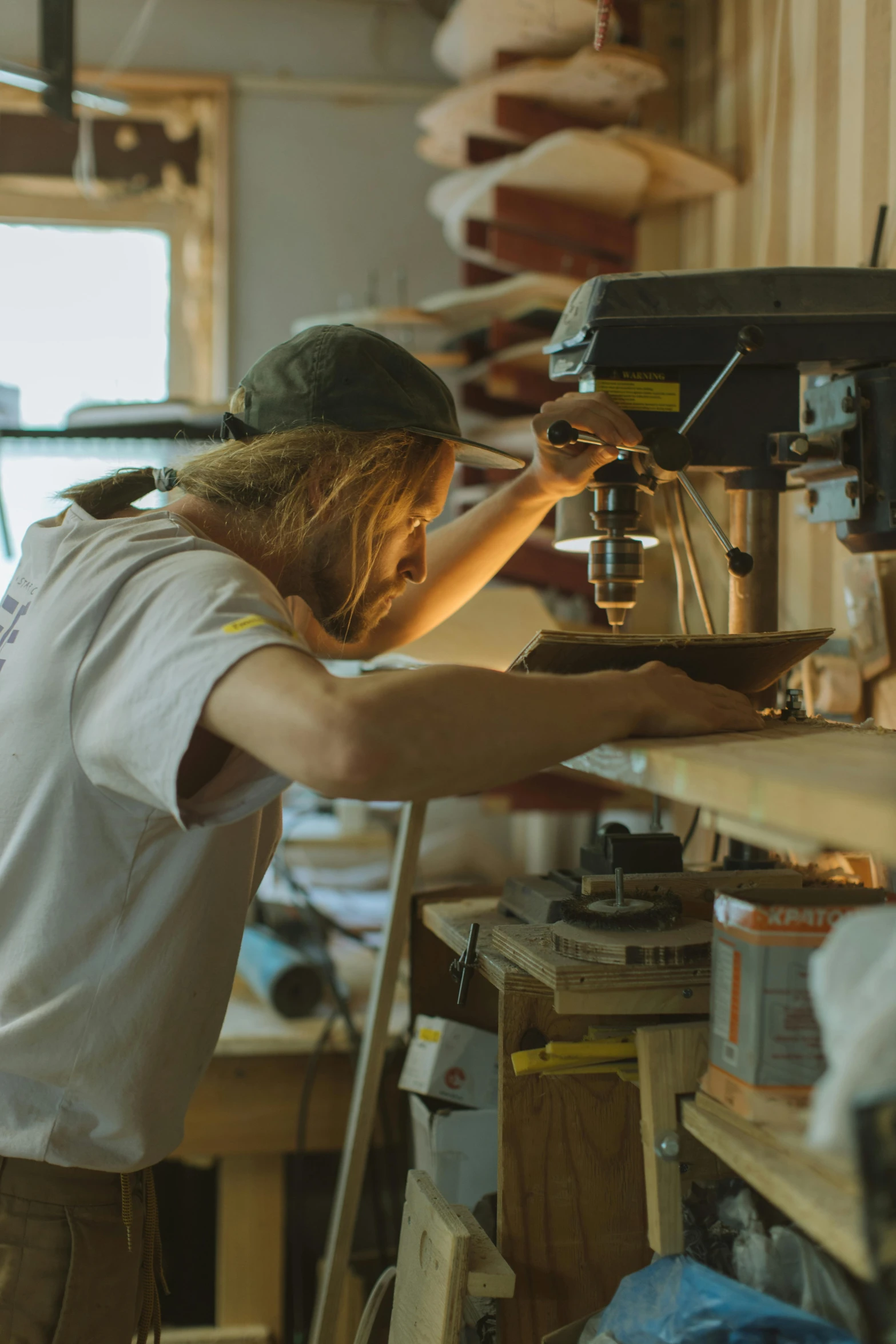 a person in white shirt using a milling machine