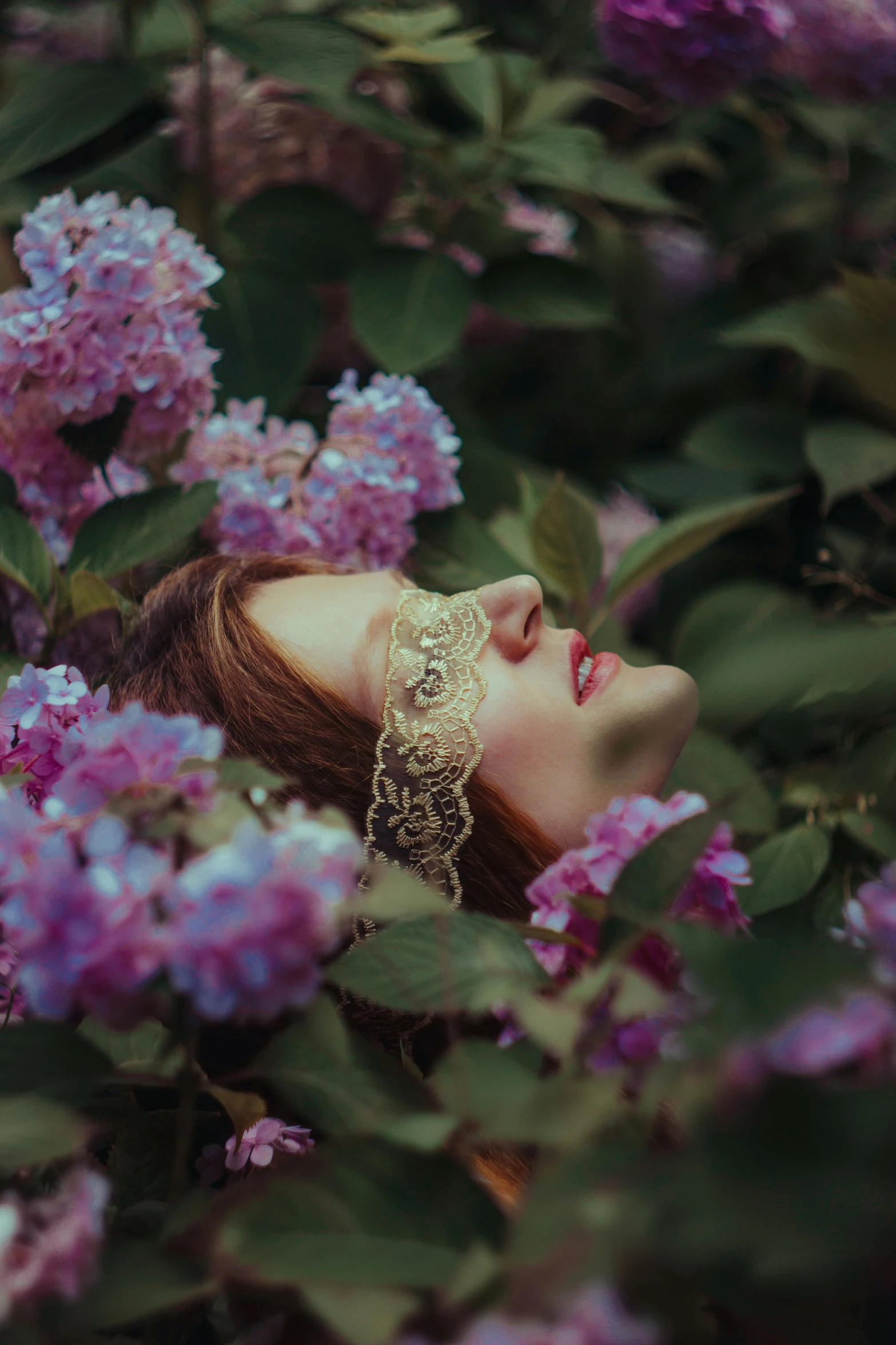 a beautiful woman in a flower field wearing necklaces