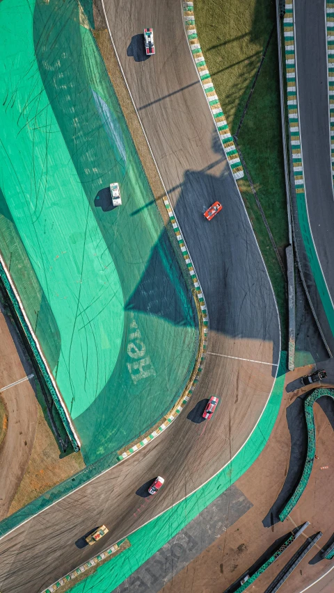 a green course with cars driving around it