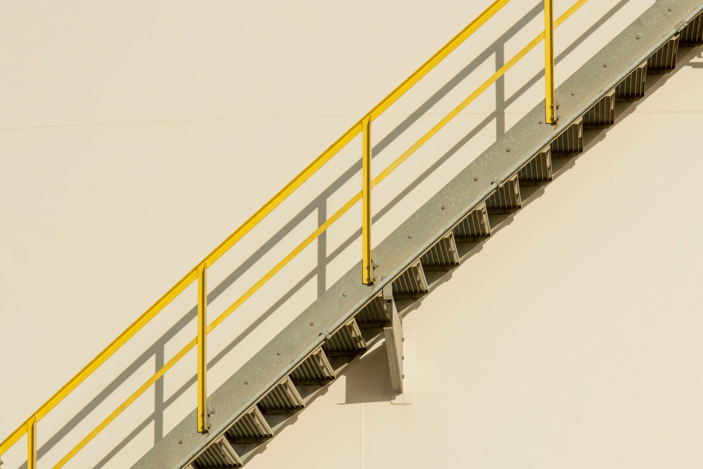 a staircase with a yellow railing above it