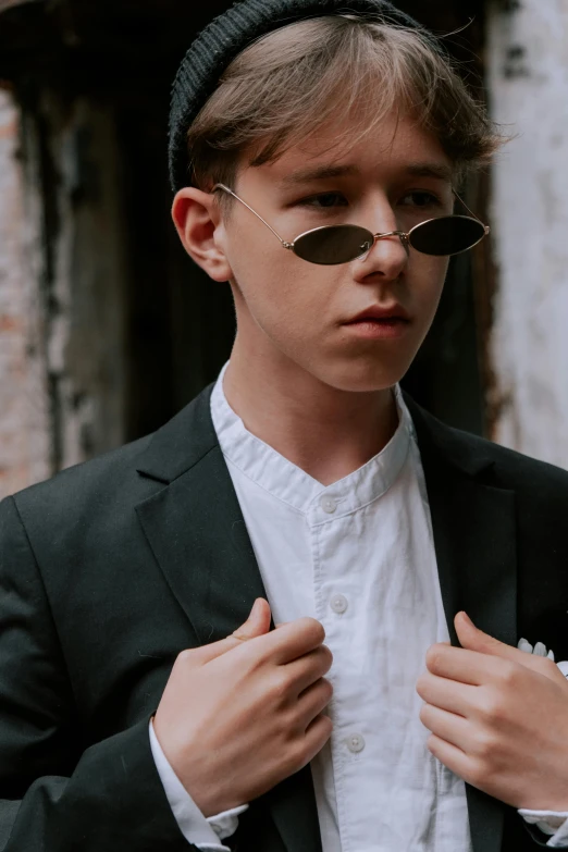 the young man is tying his jacket with sunglasses