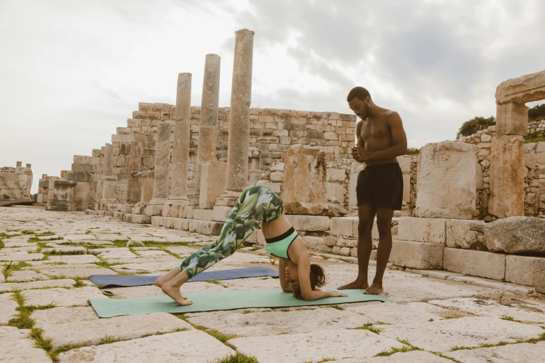 a man and a woman stretching while doing yoga