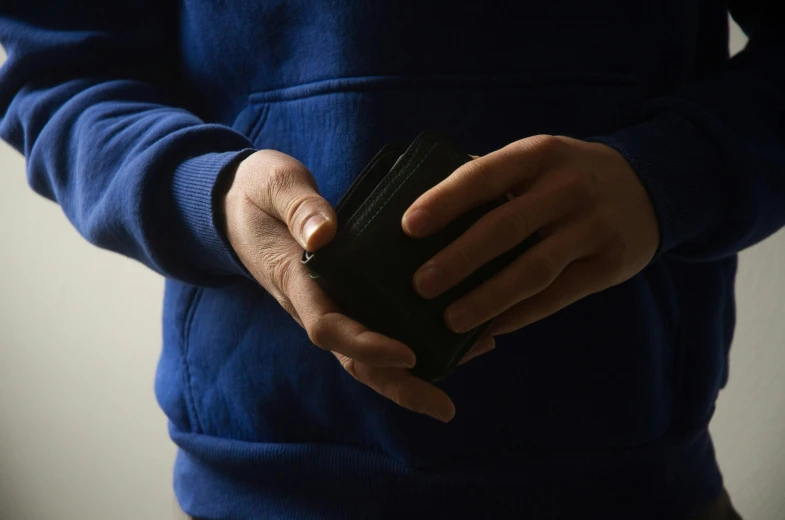 man holding a black wallet in his hand