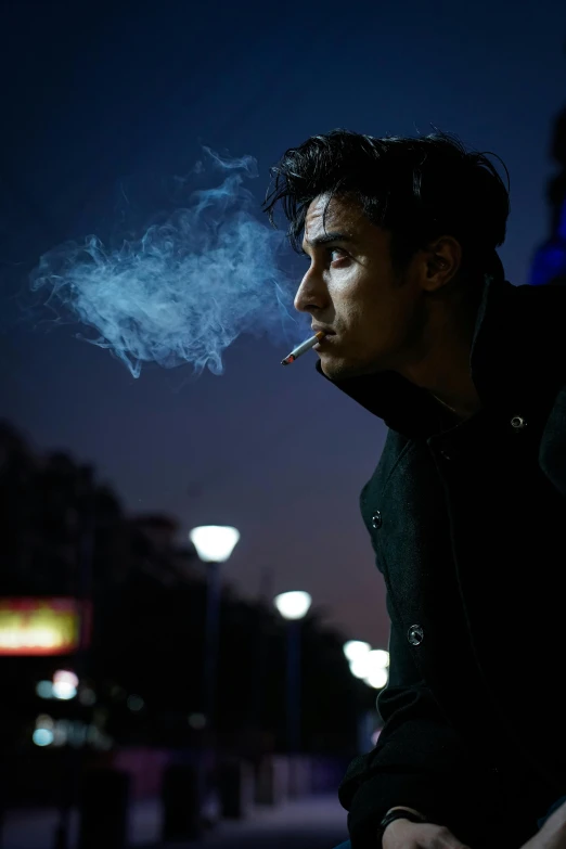 a man is smoking cigarette in the night