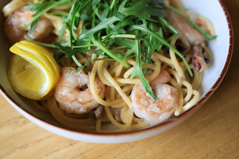 a bowl of noodles with shrimp and asparagus