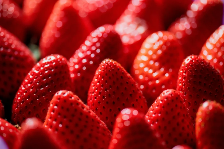 red strawberries sit in a bucket on display