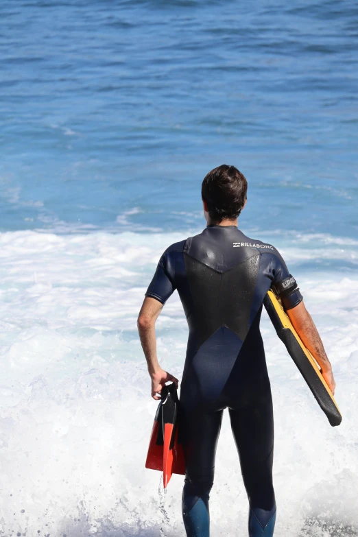 a man is standing in the water with his surfboard