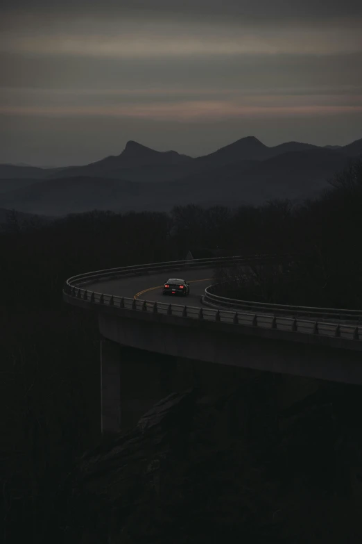 an empty highway with mountains in the background