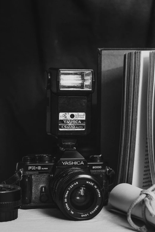 black and white pograph of camera, books and a curtain