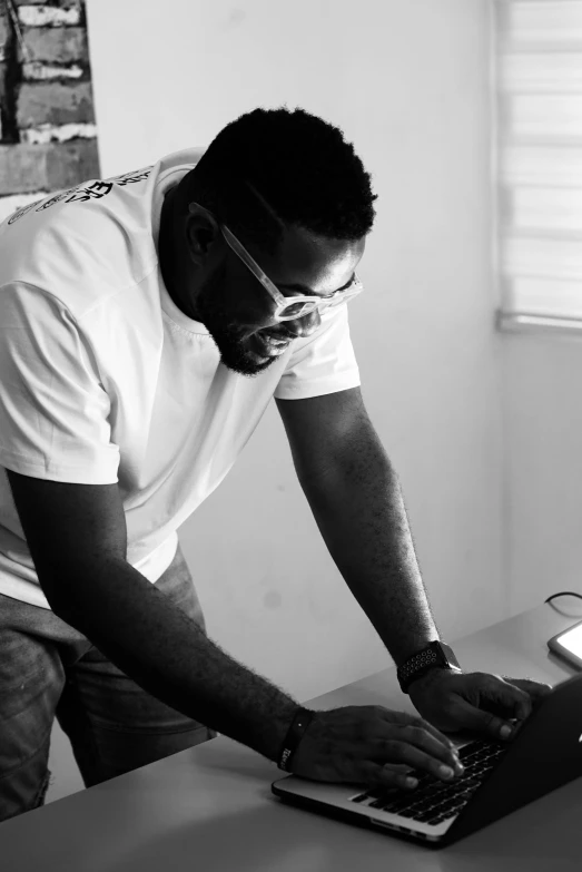 black and white pograph of man using laptop computer