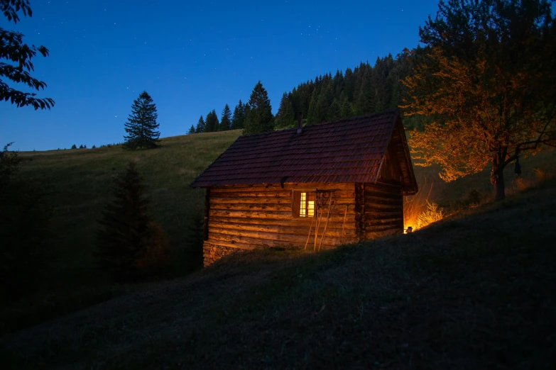 an old barn at night with the light on