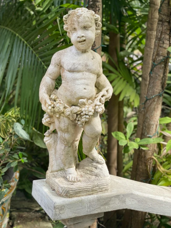 a statue of a boy holding a plant in its mouth