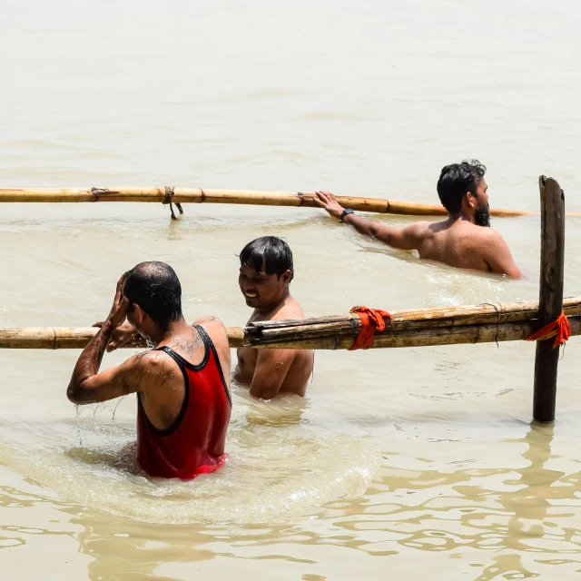 three young men playing in the water together