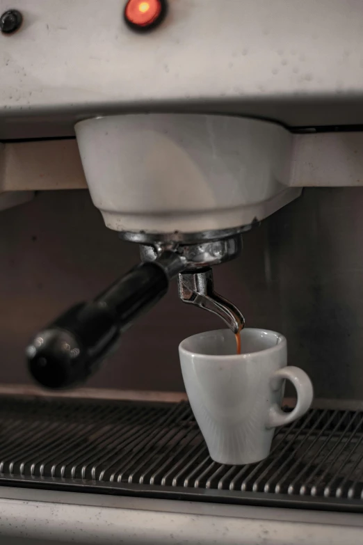 there is an espresso machine with two cups on it