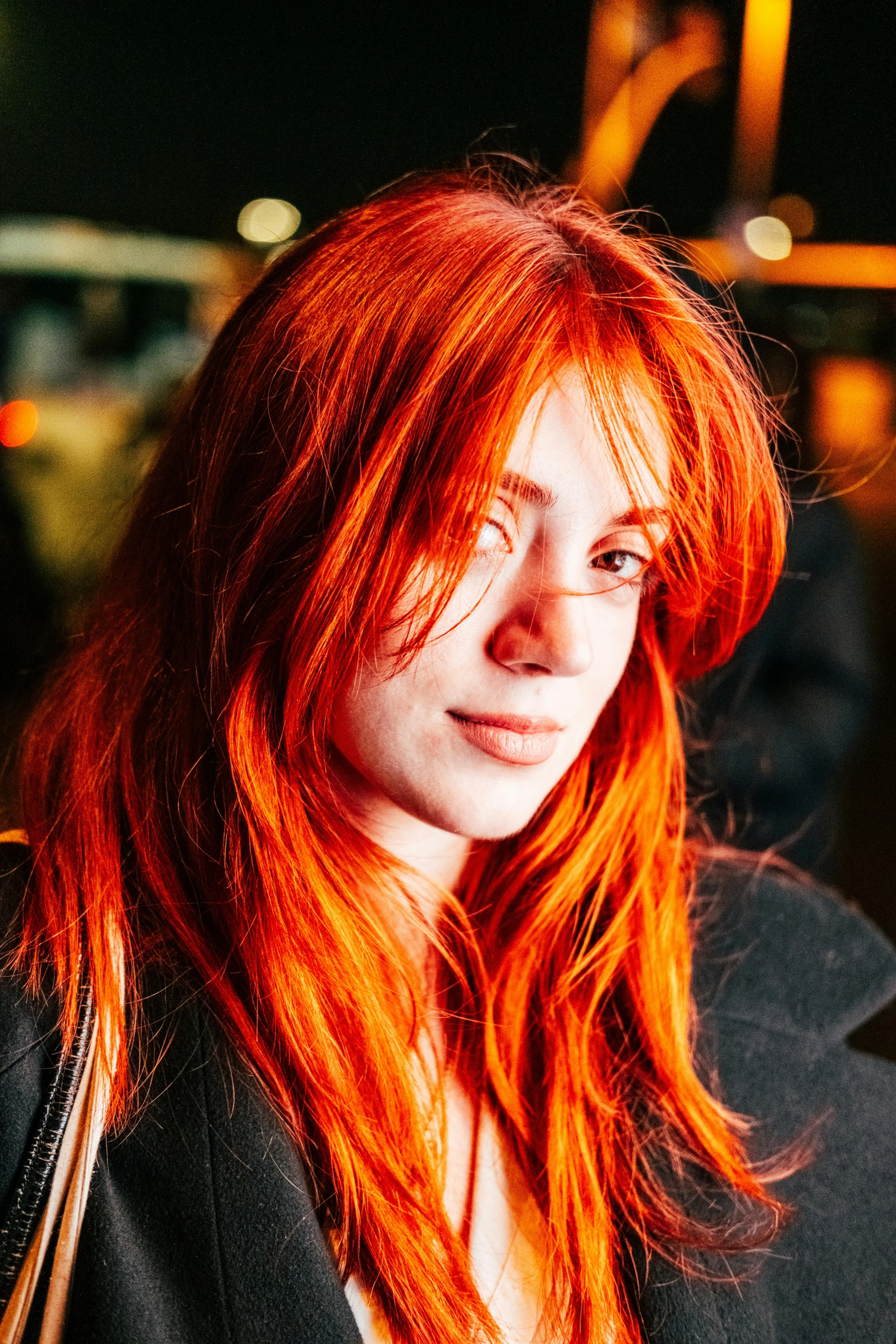 a woman with bright red hair wearing glasses