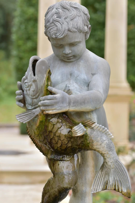 a statue holding a fish on top of a fountain