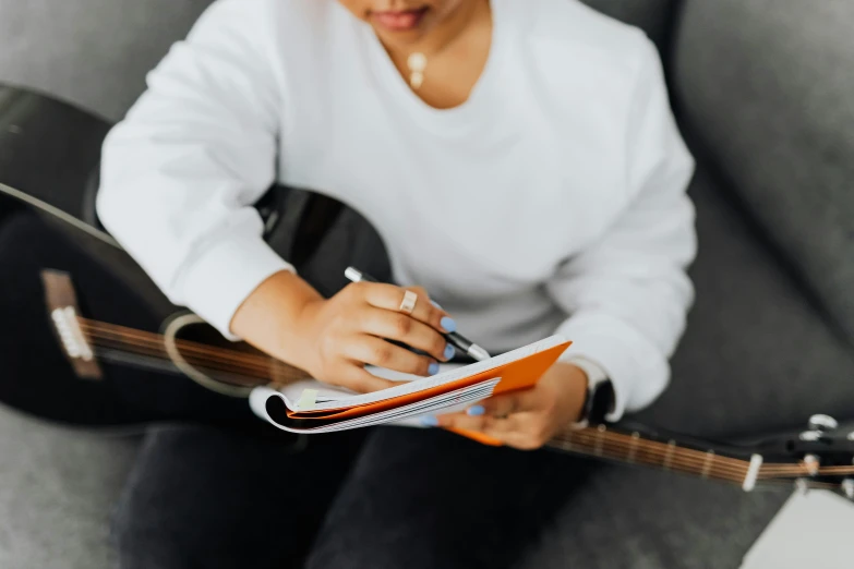 a woman sitting on top of a couch playing a guitar