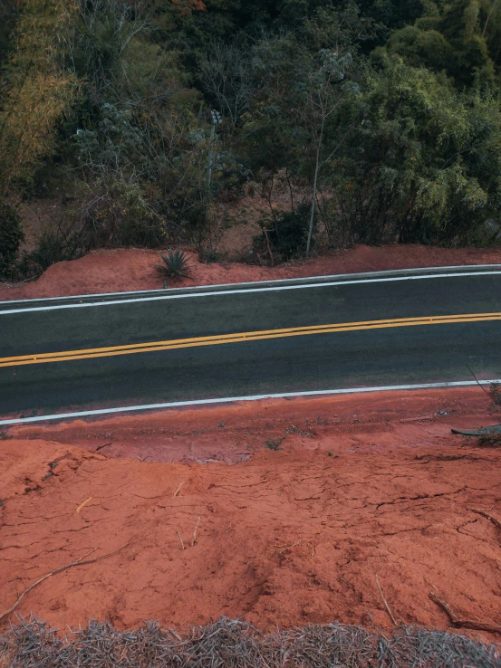 an empty road next to some trees and grass