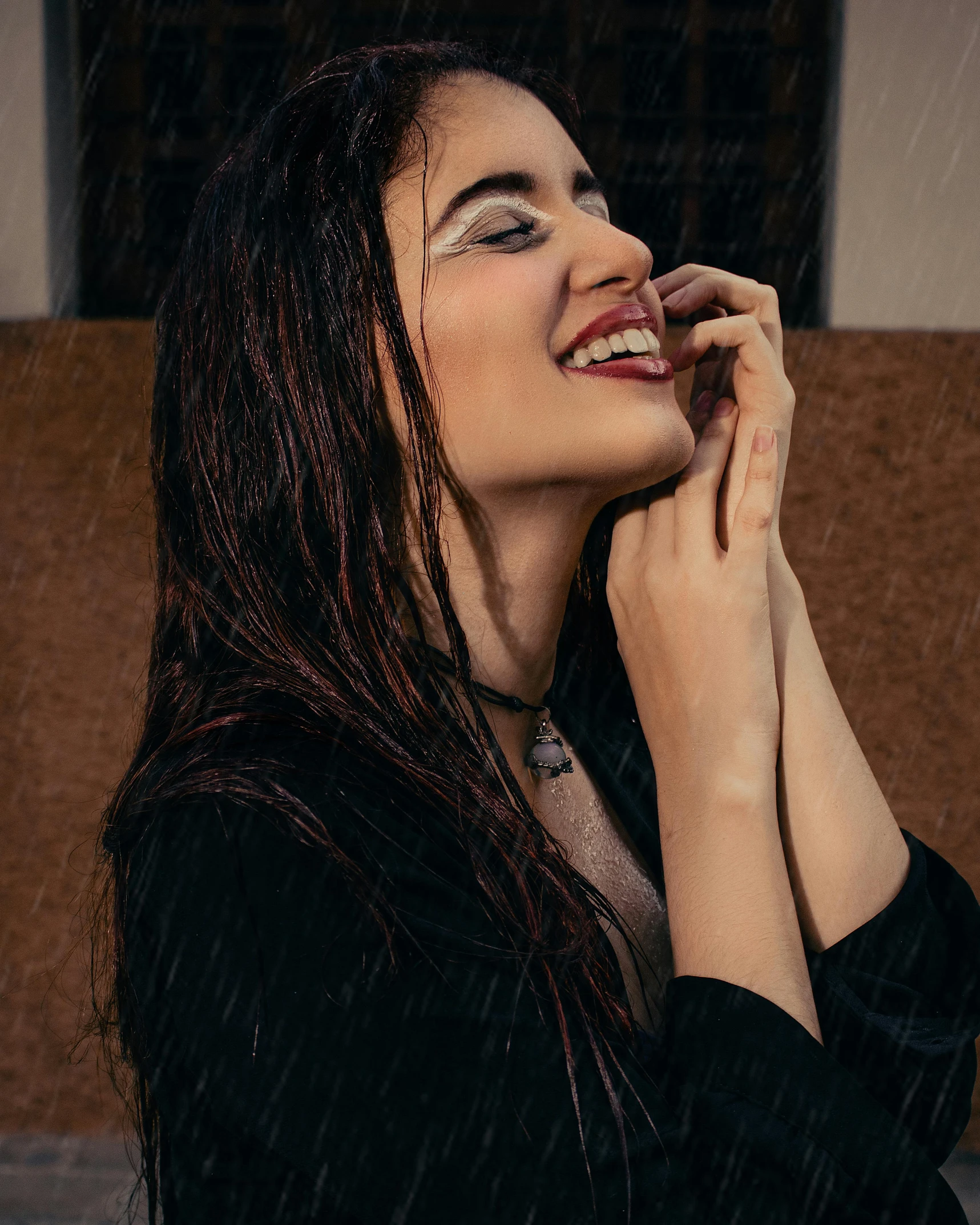 a woman in black shirt smiling in the rain