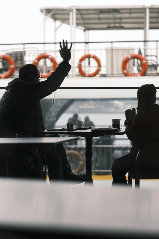 two people sitting at tables with an airplane in the background