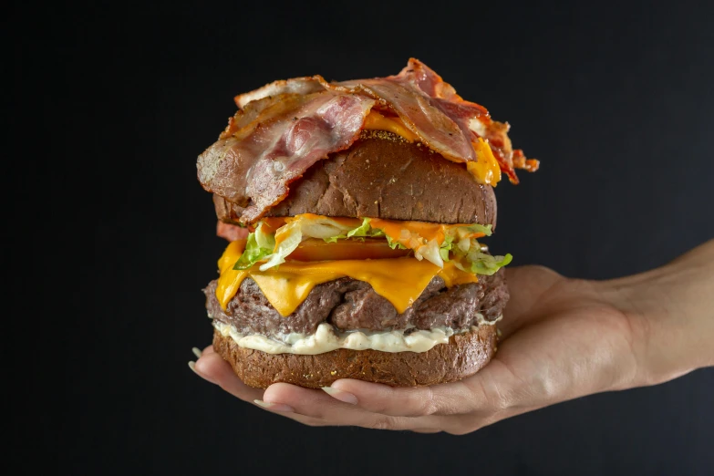 a bacon, lettuce and cheese sandwich in someones hands