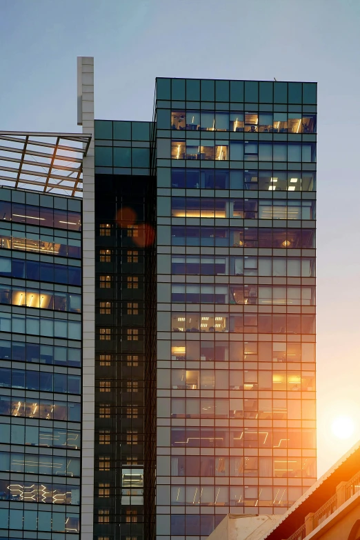 a very tall building near a bridge and the sun