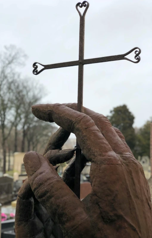 an iron cross hanging from the side of a statue