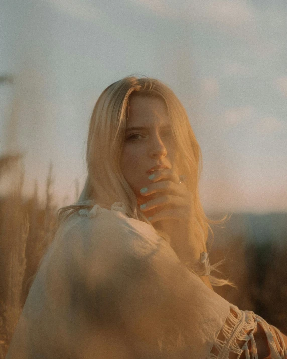 a woman is walking through tall grasses