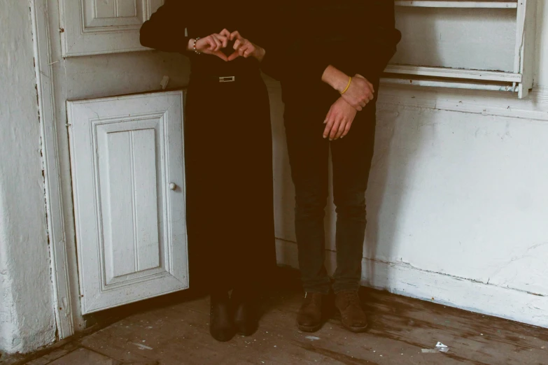 a man and woman posing for the camera in front of an open door