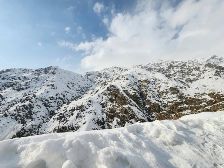 a man with ski poles stands on a mountain slope