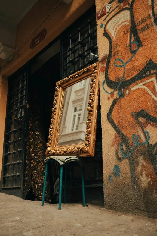 an old wooden frame with graffiti and a painting in front of it