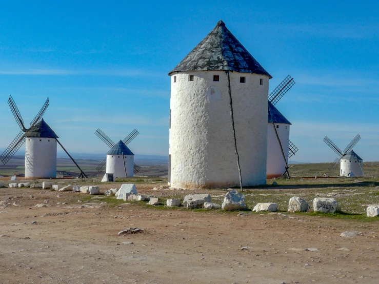 a row of windmills sit in the desert