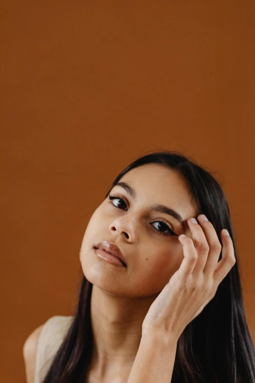 a woman in white top holding a cellphone to her ear