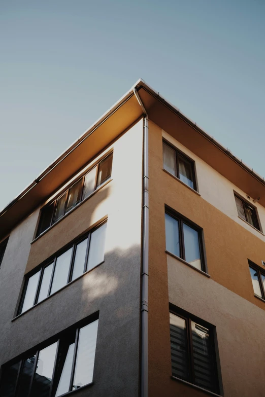 the front facade of a tan building with lots of windows