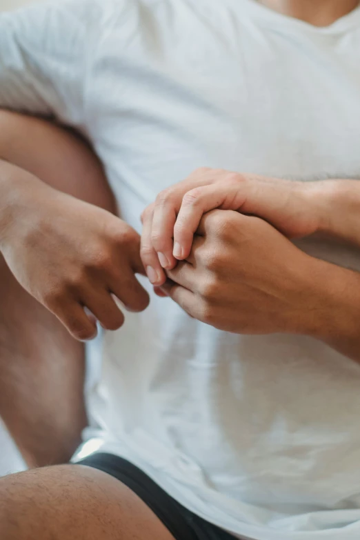 man in white shirt holding another persons hand