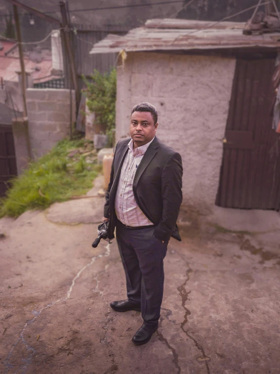 a man standing in the dirt holding a gun