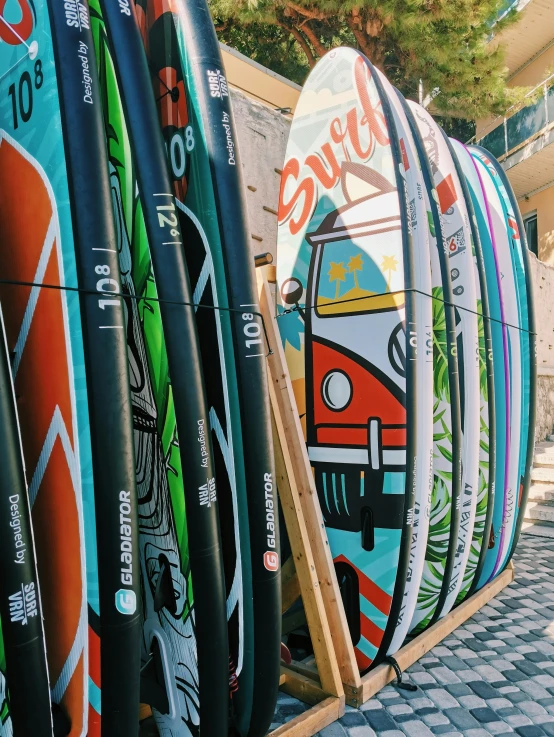 a number of surfboards standing against the wall