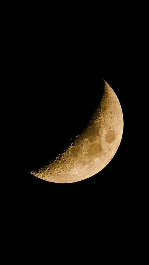 the side of a half moon is seen in dark sky