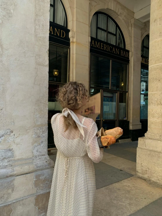 woman standing near the entrance of a building with a stuffed animal