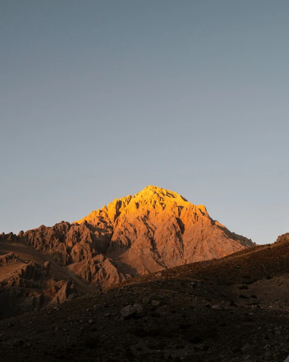 a mountain at sunset with clouds in the sky