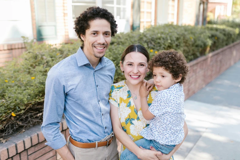 a young man standing with a woman and a little boy