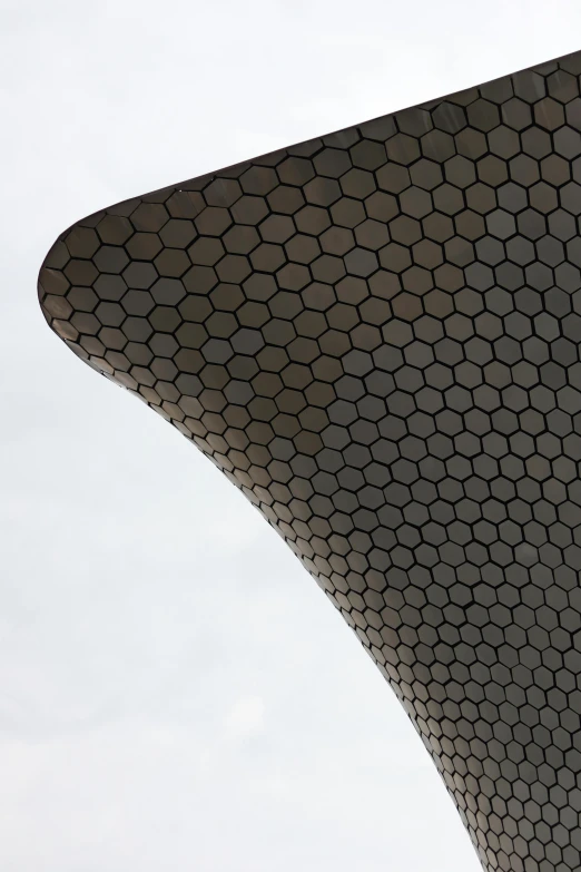 the curved facade of the building is shown against the sky