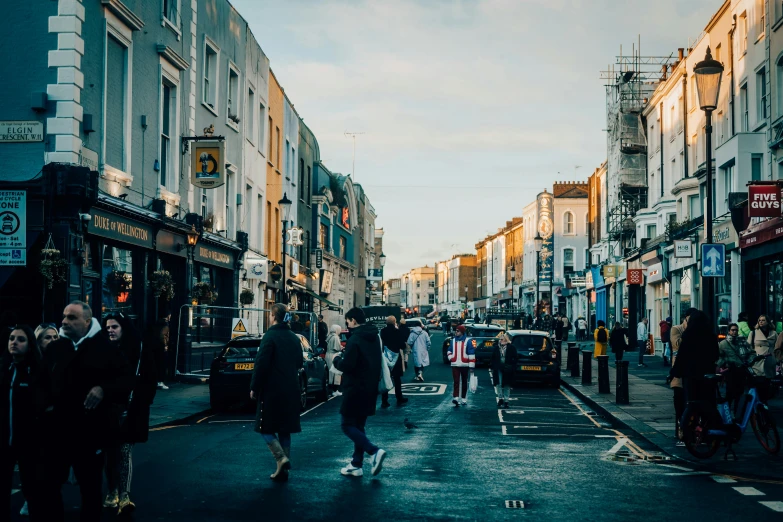 people are walking around an urban area at sunset